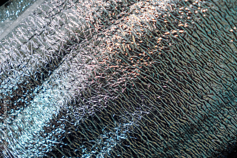 Poster striking, abstract texture featuring an array of light and shadow across a reflective, crumpled surf
