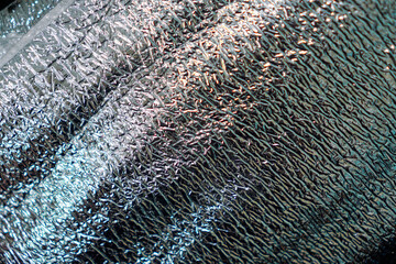 Striking, abstract texture featuring an array of light and shadow across a reflective, crumpled surface.  Great for backgrounds or overlays, conveying modernity and visual interest.