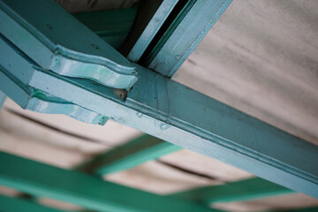 A textured, close-up view reveals layers of painted wood, connected in angular architectural...