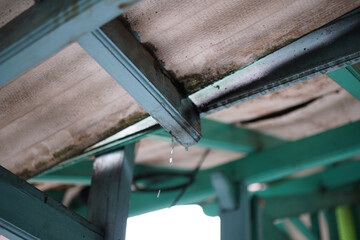 A close up shot focusing on a section of a painted wooden structure, with water droplets suspended,...