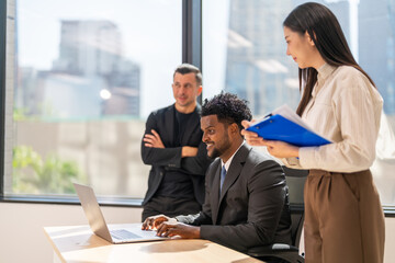 Diverse business team meeting and discussing marketing research and strategy using laptop, collaboration and communication planning, analysis, brainstorming for innovation, productivity, leadership