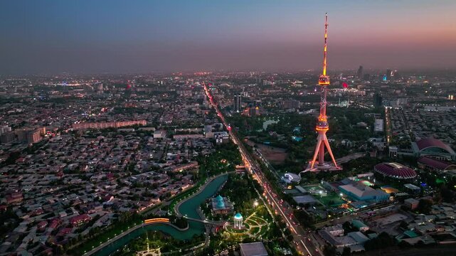 A drone over the evening streets of Tashkent against the backdrop of a sunset. View of the TV Tower