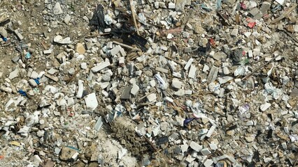 A drone captures a large pile of discarded concrete, debris, and construction waste, highlighting...