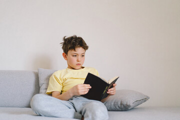 A boy is reading the holy bible and praying or meditating. Concept of Christianity, religion and...