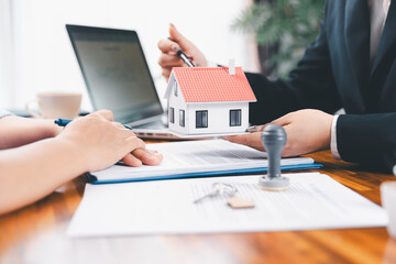 Bank approve loan to buy home concept. Real estate agent talked about terms of home purchase agreement, asked customer to sign documents to make contract legally. approved mortgage application form.
