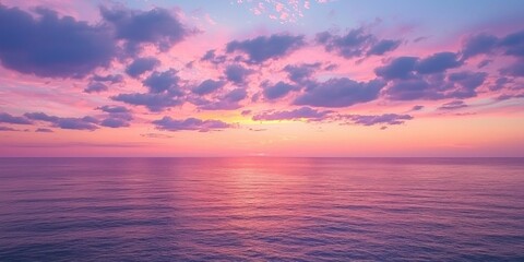 A peaceful sunset sky with soft pink and purple clouds stretching over the ocean