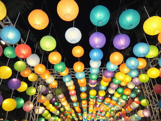Vibrant paper lanterns illuminate the night. Colorful overhead decoration for festivals, celebrations, or events. Asian culture, light, festive, party, background. © agung