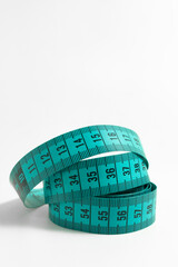 Flexible Green Measuring Tape in Spiral Form – Professional photo of a sewing tool rolled in a...