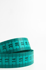 Green Tape Measure Curled on Clean Surface &ndash; Macro view of a flexible measuring tape used in tailoring and fitness. Isolated on white background with crisp detail and vibrant color.