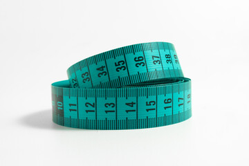 Tailor’s Measuring Tape Rolled on White Table – Precision tool for dressmaking and alterations, coiled in a loop with visible centimeter markings. Perfect for sewing and fashion visuals.