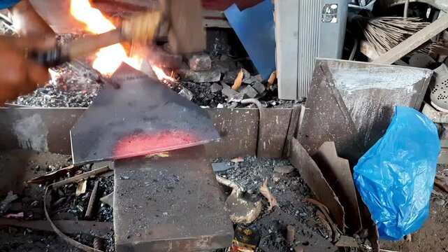 Blacksmith Forging Triangular Steel on Anvil Near Furnace