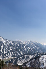 Fototapeta premium 黒部平パノラマテラスから見下ろす黒部湖と雪山の風景 