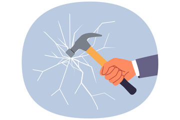 Glass breaks from blow from hammer held by hand of man trying to destroying unnecessary mirror partition. Concept of destroying barrier or vandalism during office robbery through window