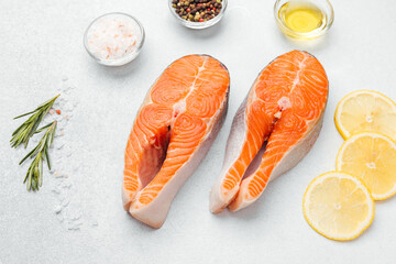 Fresh salmon fillets prepared with spices and lemon on a bright surface