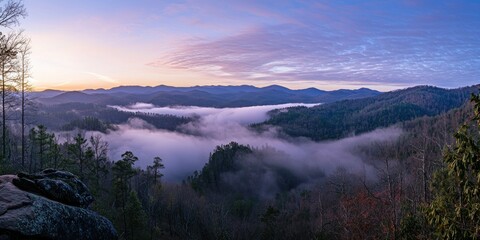 A sunrise scene where mist cascades over a vast mountain range, creating a mystical effect