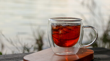 A cup of iced tea and aromatics with a blurred natural garden background