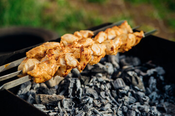 Fresh meat for barbecue, fried on fire. Selective focus. Cooking barbecue on the grill with smoke. Picnic in nature. Healthy food and proper nutrition.