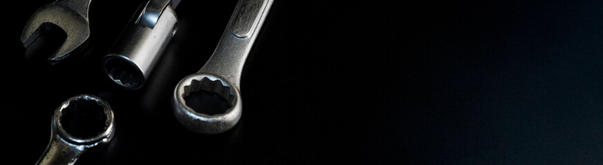 Tool set featuring chrome silver ring wrench, open end wrench, and block wrench arranged on dark background, photographed for automotive repair, industrial work, and mechanical gear content