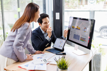 Financial analysts analyze business financial reports on a digital tablet planning investment project during a discussion at a meeting of corporate showing the results of their successful teamwork.	