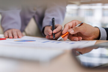 Financial analysts analyze business financial reports on a digital tablet planning investment...
