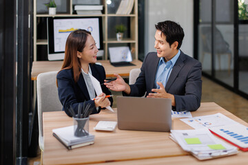 Team of Asian business people point to graphs and charts to analyze market data, balance sheet, account, net profit to plan new sales strategies to increase production capacity.
