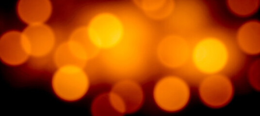 Close abstract glowing orange lights with soft blur and bokeh pattern on dark background golden...