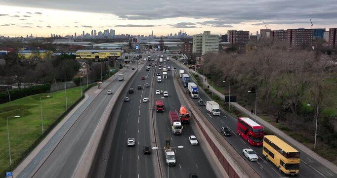 Traffic flow on track and cityscape in the background on cloudy day in the economic hub , slowmo , pull back , London UK