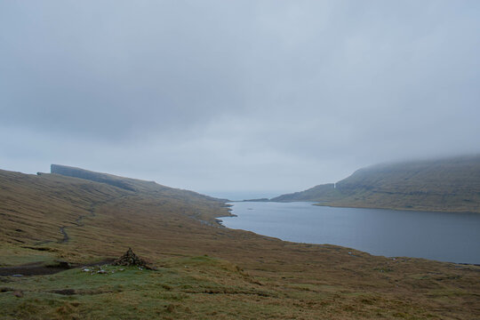 Traelanipa trail to waterfall on Vagar island, Faroe Islands, mountain ocean landscape, durring foggy day
