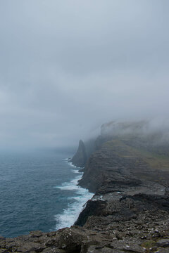 Traelanipa waterfall on Vagar island, Faroe Islands, mountain ocean landscape, durring foggy day