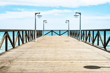 Obraz premium empty wooden pier with lamps on a sunny day