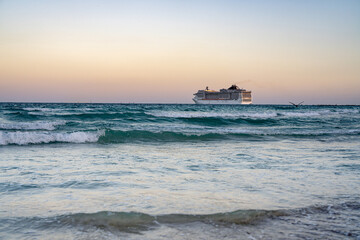 Fototapeta na wymiar Cruise ship on the ocean. Luxury liner at ocean. Miami Beach with cruise ship. Turquoise water and cruise liner. Tourist cruise ship near the coast. Ocean waves and vessel boat.