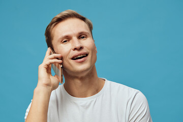 smiling man talking phone white t-shirt blue background digital nomad communication concept...
