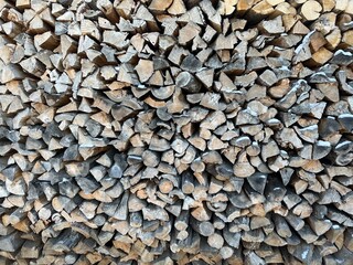 Firewood in the woodshed, preparation for the heating season in the village. Warm, brown colors, rustic style