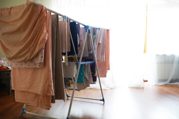 Indoor Clothes Drying Rack with Hanging Laundry in Sunlit Room