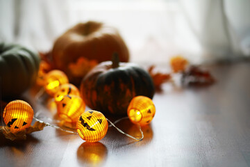 Cozy Autumn Decor with Pumpkins and Illuminated Jack-O-Lantern Lights on Wooden Floor