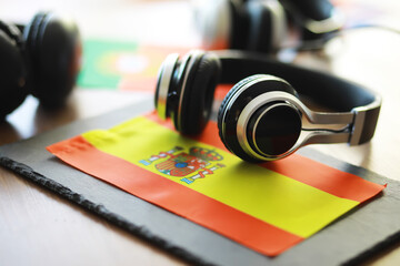 Headphones Resting on Spanish Flag - Music and Culture Concept