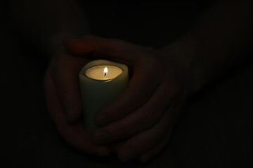 Hands Holding Lit Candle in Dark Background - Peace, Calm and Serenity