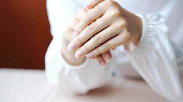 Close up of natural light on clean skin, fingers, nails, and hands gently clasped, highlighting softness and care