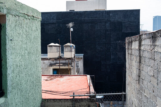 Urban rooftops in Mexico City with water tanks, weathered walls, and concrete textures, elevated view for real estate, architecture, and infrastructure stock.