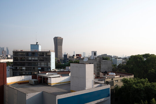 Aerial perspective of Mexico City rooftops, diverse architecture, clear sky, and modern skyline, perfect for business, cityscape, and editorial use in urban themes.