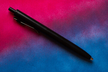 青と赤の背景に置いてあるボールペン	