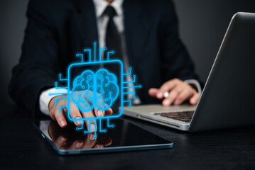 Businessman using digital tablet and laptop, with holographic brain icon artificial intelligence. concept innovation, data processing, machine learning, and technology AI, digital transformation.