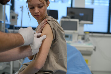 Vaccination of teenage girl during routine health checkup at hospital.