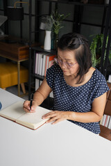 Senior Asian woman Write a diary in a notebook