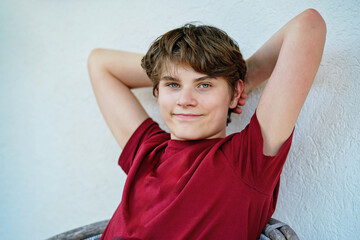 Portrait of smiling teenage schoolboy looking at camera. Happy teenage boy, smiling confidently...