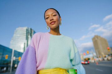 Fashion model posing in pastel colors sweater in urban cityscape