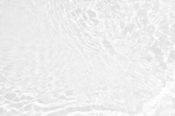 White water with ripples on the surface. Defocus blurred transparent white colored clear calm water surface texture with splashes and bubbles. Water waves with shining pattern texture background.