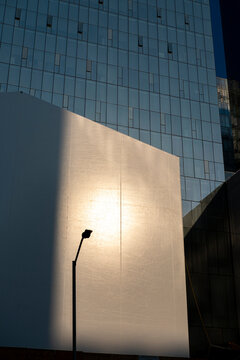 Golden light on minimalist white building facade, geometric shapes, shadows and light contrast in modern architecture for design, background and editorial visuals.