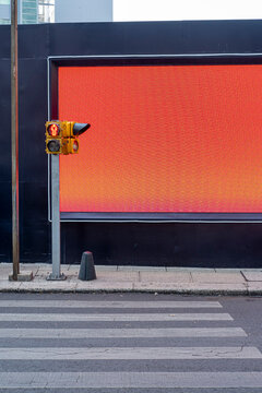 Minimalist crosswalk and traffic light against bold red billboard in cityscape, color contrast, geometry and modern design for business, design and branding stock.