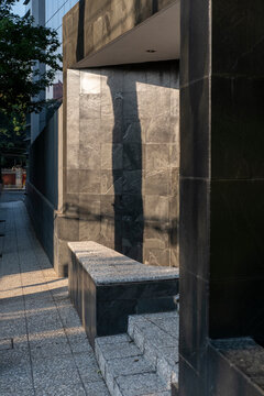 Urban textures of concrete benches and dark stone walls, architectural geometry and light for cityscape, design and architecture stock applications.